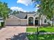 Charming single-story home with a well-manicured lawn and three-car garage at 20835 Lake Talia Blvd, Land O Lakes, FL 34638