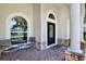 Inviting front porch with seating area and charming curb appeal with arched windows at 20835 Lake Talia Blvd, Land O Lakes, FL 34638