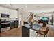 Open-concept kitchen featuring a black granite island with seating, stainless steel appliances, and staircase at 20835 Lake Talia Blvd, Land O Lakes, FL 34638