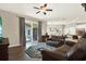 Open-concept living room with hardwood floors, a ceiling fan, and sliding glass doors leading to the patio at 20835 Lake Talia Blvd, Land O Lakes, FL 34638