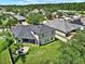 Backyard view of neutral colored home with dark roof, patio, and green grass in a neighborhood at 20835 Lake Talia Blvd, Land O Lakes, FL 34638