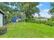 Expansive backyard with a well-manicured lawn, mature trees, and inviting landscaping at 217 W Powhatan Ave, Tampa, FL 33604