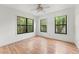 Bright bedroom features hardwood floors and three windows offering outdoor views at 217 W Powhatan Ave, Tampa, FL 33604