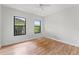 White bedroom with hardwood floors and two windows overlooking lush greenery at 217 W Powhatan Ave, Tampa, FL 33604