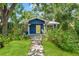 Charming blue home featuring lush landscaping and a well-manicured lawn at 217 W Powhatan Ave, Tampa, FL 33604