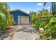 Garage with a porch swing and surrounded by greenery at 217 W Powhatan Ave, Tampa, FL 33604