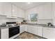 Traditional kitchen with white cabinets, a gas stove and a view to the backyard at 217 W Powhatan Ave, Tampa, FL 33604