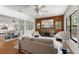 Bright living room featuring hardwood floors, a stone fireplace and a ceiling fan at 217 W Powhatan Ave, Tampa, FL 33604