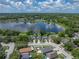 Stunning aerial view of home on a lake with lush surrounding greenery and a blue sky with fluffy clouds at 22829 Saint Thomas Cir, Lutz, FL 33549