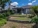 This backyard has a retaining wall, lush plants, and a screened lanai at 22829 Saint Thomas Cir, Lutz, FL 33549