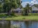 Backyard featuring a scenic lake view and mature, lush tropical landscaping at 22829 Saint Thomas Cir, Lutz, FL 33549
