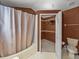 Bathroom featuring a shower-tub, toilet, and closet with shelving at 22829 Saint Thomas Cir, Lutz, FL 33549