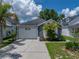 Well-maintained single Gathering home featuring a two-car garage, lush landscaping, and a paved driveway at 22829 Saint Thomas Cir, Lutz, FL 33549