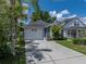 Single Gathering home with a two-car garage, lush landscaping, and a well-maintained front lawn at 22829 Saint Thomas Cir, Lutz, FL 33549