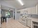Cozy kitchen features white appliances, adjacent breakfast nook, and screened patio view at 22829 Saint Thomas Cir, Lutz, FL 33549