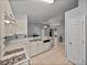 Open layout of the kitchen featuring white appliances, tile floors, and breakfast bar overlooking living room at 22829 Saint Thomas Cir, Lutz, FL 33549