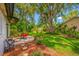 Lush backyard featuring a patio area, mature trees, and well-maintained lawn at 2308 Cape Bend Ave, Tampa, FL 33613