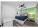 Bedroom featuring hardwood floors, a bed, and a bright green accent wall at 2308 Cape Bend Ave, Tampa, FL 33613