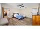 Bedroom featuring hardwood floors, ceiling fan, and neutral-toned walls with blue bedding at 2308 Cape Bend Ave, Tampa, FL 33613