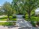A single-story home with a two car garage, surrounded by lush greenery and mature trees at 2308 Cape Bend Ave, Tampa, FL 33613