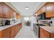 Well-lit kitchen with stainless steel appliances, spacious countertops, and warm wood cabinets at 2308 Cape Bend Ave, Tampa, FL 33613