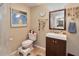 Cozy bathroom featuring a vanity sink, neutral-colored walls, and a decorative mirror reflecting the primary bedroom at 2848 Homewood St, Clearwater, FL 33759