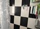 Close up of black and white checkered tiled shower with toiletries at 2909 N 11Th St, Tampa, FL 33605