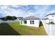 Rear view of home and fenced backyard with green grass at 29245 Fedora Cir, Brooksville, FL 34602