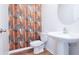 Bathroom featuring wood-look flooring, a pedestal sink, commode, and a vertically stacked, multi-colored wooden patterned wallpaper at 29245 Fedora Cir, Brooksville, FL 34602