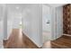 Spacious hallway showing view into bedroom with carpet and a bathroom with vertically stacked wooden pattern wallpaper at 29245 Fedora Cir, Brooksville, FL 34602