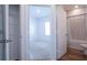 Open doorway reveals a view of a bathroom with a shower/tub combo, and a glimpse of a bedroom with carpet at 29245 Fedora Cir, Brooksville, FL 34602