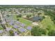 Community aerial view with pond featuring multiple homes and verdant green spaces and walking path at 301 Canton Ct # 77, Sun City Center, FL 33573