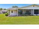 Green backyard with a screen porch, offering outdoor enjoyment at 301 Canton Ct # 77, Sun City Center, FL 33573