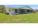 Exterior view of the backyard with screen porch and lush lawn at 301 Canton Ct # 77, Sun City Center, FL 33573