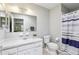 Well-lit bathroom with white cabinets, large mirror, toilet and shower at 301 Canton Ct # 77, Sun City Center, FL 33573