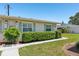 Charming home exterior featuring a neatly landscaped yard, walkway, and vibrant green bushes at 301 Canton Ct # 77, Sun City Center, FL 33573