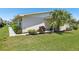 Well-maintained home exterior with lush landscaping, charming flowerbeds, and a vibrant palm tree at 301 Canton Ct # 77, Sun City Center, FL 33573