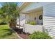 Inviting front porch with tropical plants, flowers, and a decorative wreath on the door at 301 Canton Ct # 77, Sun City Center, FL 33573