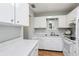 Bright kitchen featuring white cabinets, white appliances, and durable countertop at 301 Canton Ct # 77, Sun City Center, FL 33573