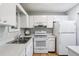 Well-lit kitchen with white cabinets and appliances, offering a clean and functional space at 301 Canton Ct # 77, Sun City Center, FL 33573