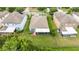 Aerial view of the fenced backyards, lawns, and patios of three homes in a neighborhood at 3025 Winglewood Cir, Lutz, FL 33558