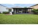 Expansive backyard features green grass, an enclosed patio, and a well-maintained lawn at 3025 Winglewood Cir, Lutz, FL 33558