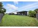 A fenced backyard showcases a screened-in patio with outdoor furniture and manicured green lawn at 3025 Winglewood Cir, Lutz, FL 33558