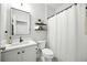 Bright bathroom features a white vanity, framed mirror, and shower with a textured curtain at 3025 Winglewood Cir, Lutz, FL 33558