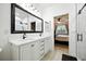 Stylish bathroom with double sinks, a large mirror, and a view into the adjacent bedroom at 3025 Winglewood Cir, Lutz, FL 33558