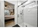 Contemporary bathroom with a glass shower, rain shower head, and a view into the main bedroom at 3025 Winglewood Cir, Lutz, FL 33558