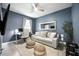 Bedroom is designed with a blue accent wall, cozy couch, and a well-lit desk space at 3025 Winglewood Cir, Lutz, FL 33558