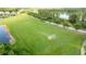 Aerial view of a large sports field with soccer goals in a residential area near a pond at 3025 Winglewood Cir, Lutz, FL 33558