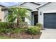 Close up of the front of the house, showing the door, landscaping, and two car garage at 3025 Winglewood Cir, Lutz, FL 33558