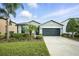 Charming single-story home featuring lush landscaping and a well-maintained lawn and a two car garage at 3025 Winglewood Cir, Lutz, FL 33558